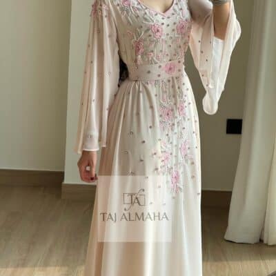 Elegant blush pink embroidered traditional dress with floral details by Taj Al Mahah.