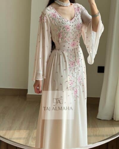 Elegant blush pink embroidered traditional dress with floral details by Taj Al Mahah.