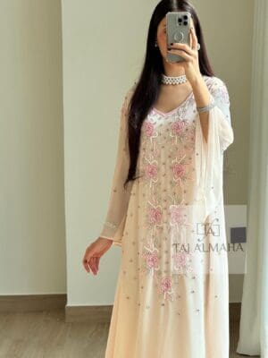 Elegant peach-colored embroidered dress with floral details and pearls, perfect for special occasions.