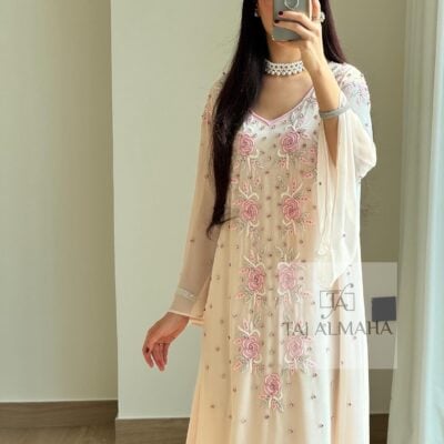 Elegant peach-colored embroidered dress with floral details and pearls, perfect for special occasions.