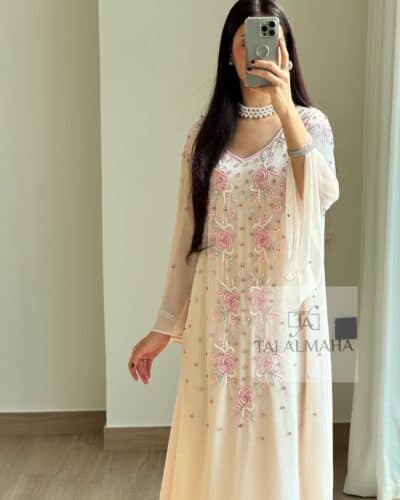 Elegant peach-colored embroidered dress with floral details and pearls, perfect for special occasions.
