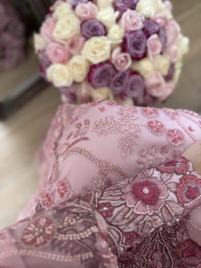 Elegant pink embroidered dress with floral patterns and sequins.