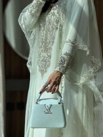 img_3907 Luxurious embroidered traditional dress with designer handbag showcasing elegance and style at Taj Al Maha.