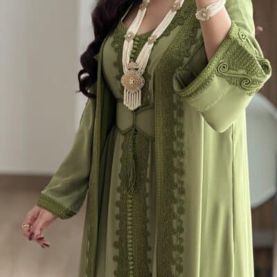 Elegant green embroidered abaya with intricate detailing and matching jewelry from Taj Al Maha.