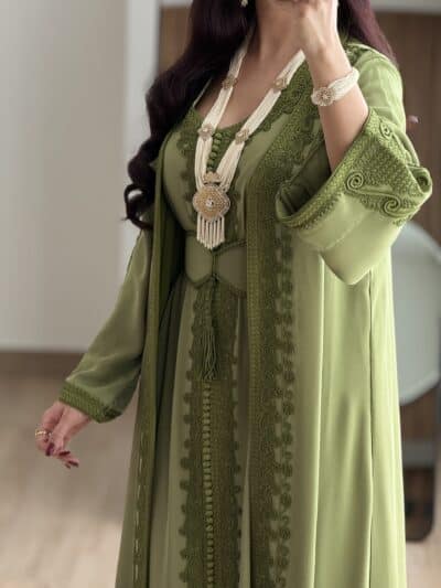 Elegant green embroidered abaya with intricate detailing and matching jewelry from Taj Al Maha.