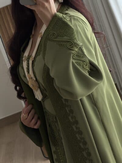 Elegant green embroidered traditional dress worn by a woman, showcasing intricate craftsmanship and cultural elegance.