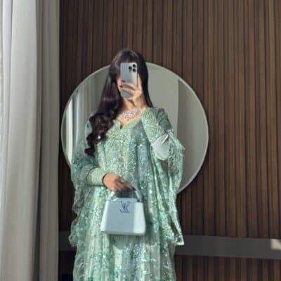 Luxurious emerald green embellished gown from Taj Al Maha for elegant occasions.