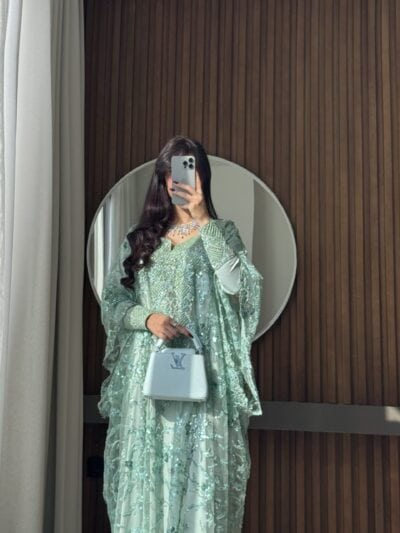 Luxurious emerald green embellished gown from Taj Al Maha for elegant occasions.
