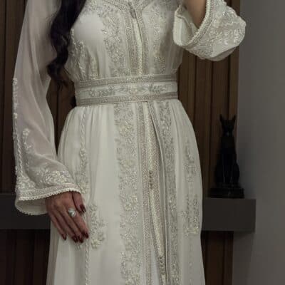 Elegant white embroidered dress with intricate beadwork and traditional design, perfect for special occasions.