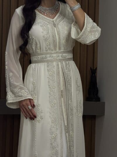 Elegant white embroidered dress with intricate beadwork and traditional design, perfect for special occasions.