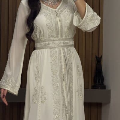 Elegant white embroidered kaftan with silver beadwork, perfect for special occasions and celebrations at Taj Al Mahaa.