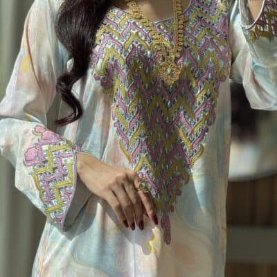 Elegant embroidered traditional dress with gold jewelry for cultural attire.