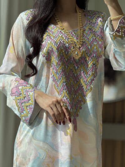 Elegant embroidered traditional dress with gold jewelry for cultural attire.