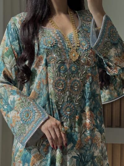 Intricate floral embroidered traditional dress with gold jewelry from Taj Almaha, showcasing cultural fashion sophistication.