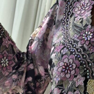 Luxury embroidered floral dress with intricate beadwork and pink floral print, designed by TAJ ALMAHA for elegant occasions.