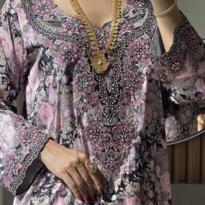 Intricate floral embroidered traditional dress with gold jewelry for cultural events.