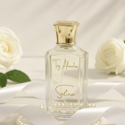 Luxurious Taj Almaha Selina perfume bottle with elegant gold cap, surrounded by white roses and pearls, epitomizing sophistication.