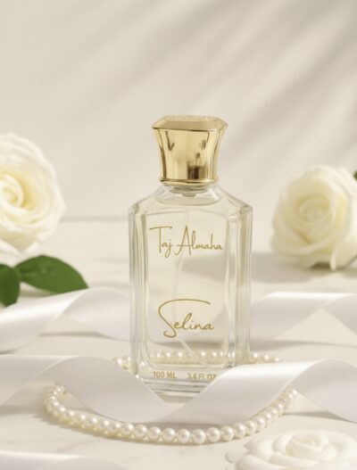 Luxurious Taj Almaha Selina perfume bottle with elegant gold cap, surrounded by white roses and pearls, epitomizing sophistication.